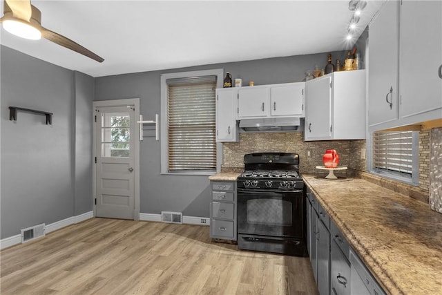 kitchen with light wood-type flooring, tasteful backsplash, black gas range oven, ceiling fan, and white cabinets