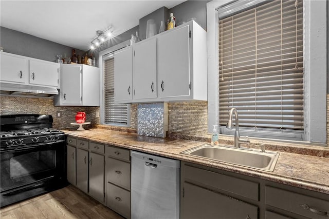 kitchen with dishwasher, black gas stove, decorative backsplash, and sink