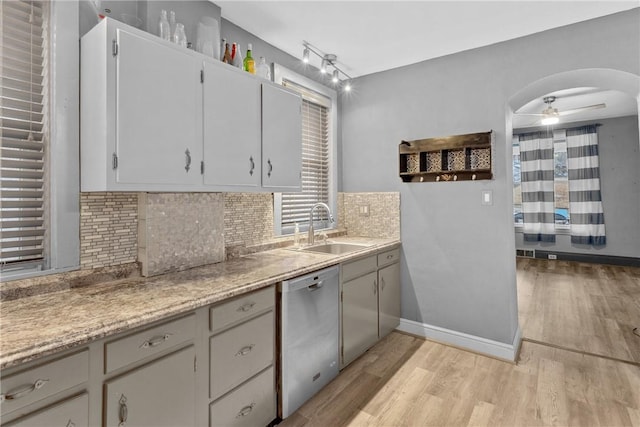 kitchen with white cabinets, tasteful backsplash, sink, light hardwood / wood-style flooring, and dishwasher