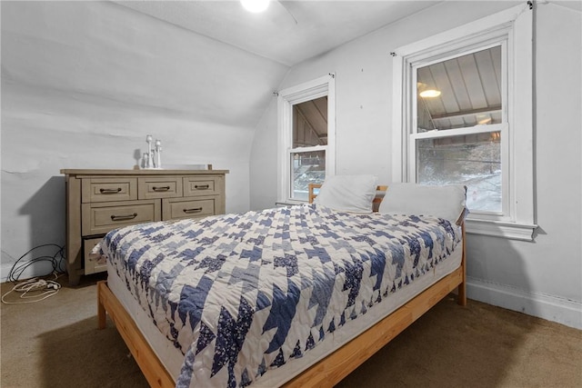 carpeted bedroom with ceiling fan and vaulted ceiling