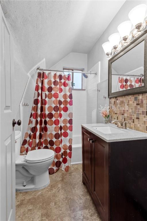 full bathroom featuring backsplash, vaulted ceiling, toilet, shower / bath combo with shower curtain, and vanity