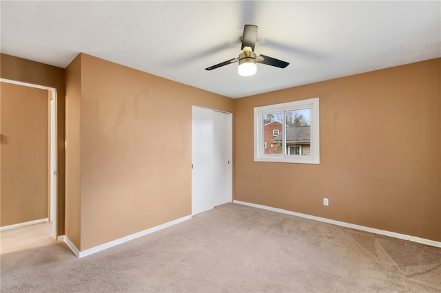 unfurnished bedroom featuring light carpet, a closet, and ceiling fan