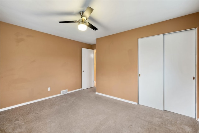 unfurnished bedroom featuring carpet, a closet, and ceiling fan