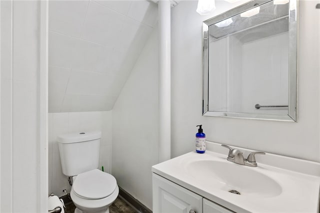 bathroom featuring vanity, vaulted ceiling, and toilet