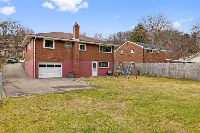 rear view of property with a yard, central AC, and a garage