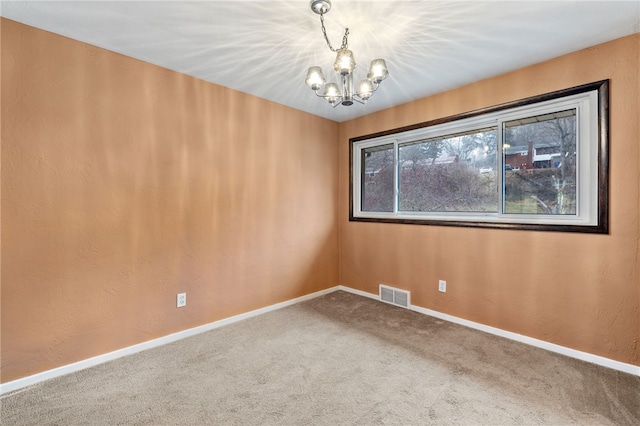 empty room with a chandelier and carpet floors