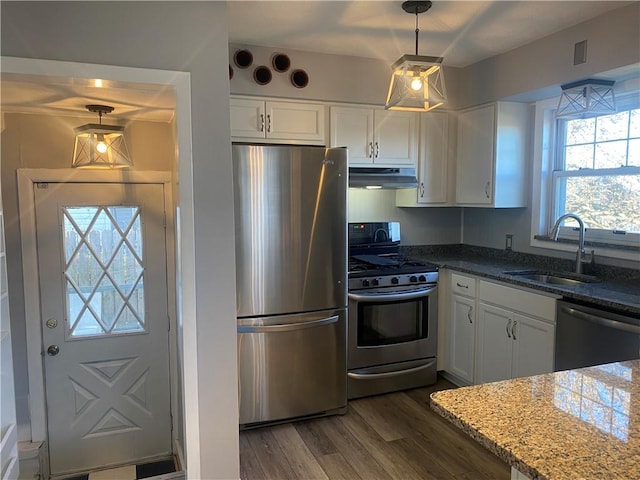 kitchen featuring appliances with stainless steel finishes, white cabinetry, pendant lighting, and sink