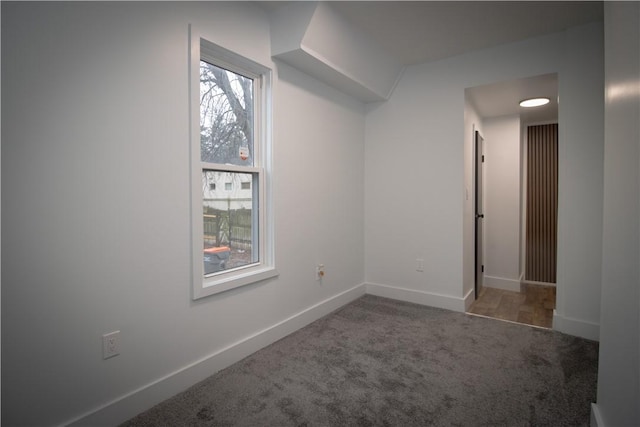 unfurnished room featuring dark carpet