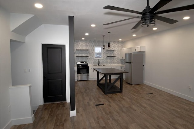 kitchen with stainless steel appliances, white cabinetry, hanging light fixtures, and sink