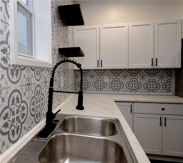 kitchen featuring white cabinetry and sink