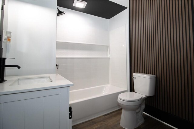 full bathroom with vanity, toilet, wood-type flooring, and washtub / shower combination