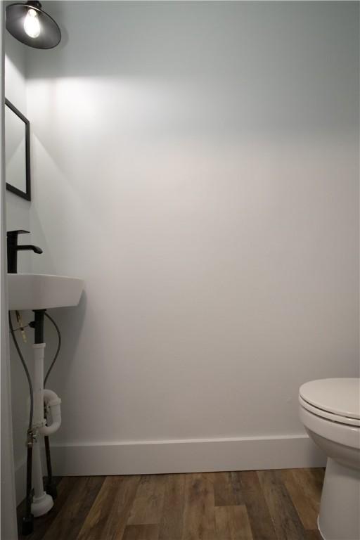 bathroom featuring hardwood / wood-style flooring, toilet, and sink