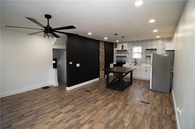 kitchen featuring white cabinetry, sink, hanging light fixtures, stainless steel appliances, and dark hardwood / wood-style flooring