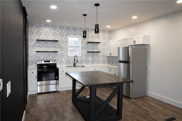 kitchen with sink, appliances with stainless steel finishes, white cabinetry, dark hardwood / wood-style flooring, and decorative light fixtures