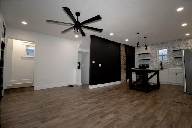 kitchen featuring dark wood-type flooring, white cabinets, ceiling fan, stainless steel fridge, and decorative light fixtures