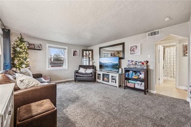 carpeted living room featuring a textured ceiling