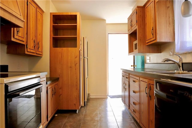 kitchen featuring dishwasher, dark tile patterned floors, sink, premium range hood, and stove