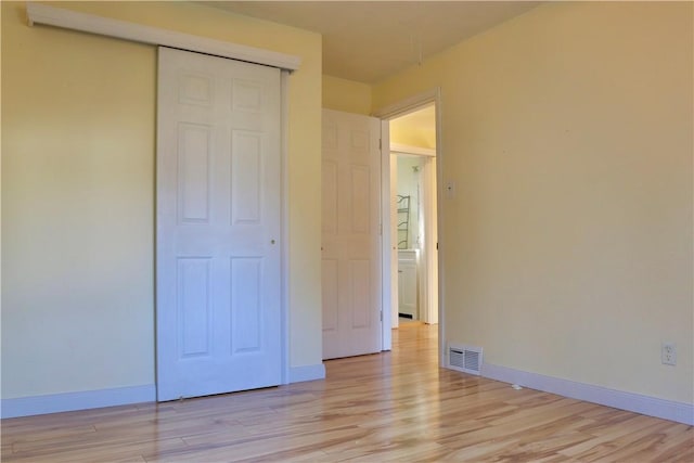 unfurnished bedroom featuring light hardwood / wood-style flooring and a closet