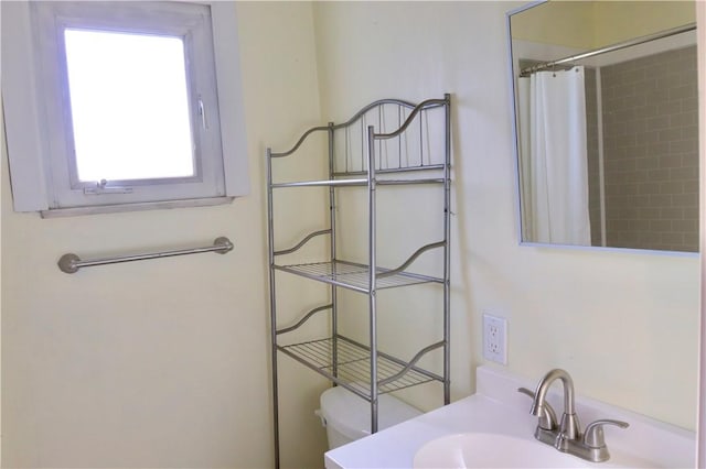 bathroom featuring a shower with shower curtain, toilet, and sink