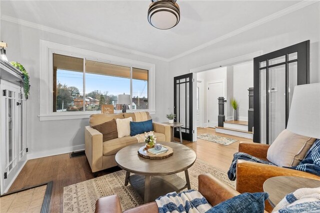 living room with crown molding and hardwood / wood-style flooring