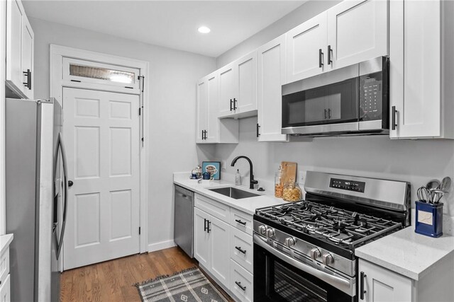 kitchen featuring white cabinets, appliances with stainless steel finishes, dark hardwood / wood-style floors, and sink