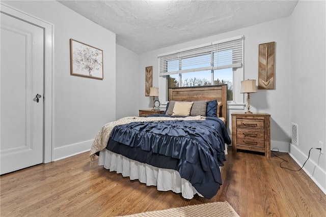 bedroom featuring wood-type flooring and a textured ceiling