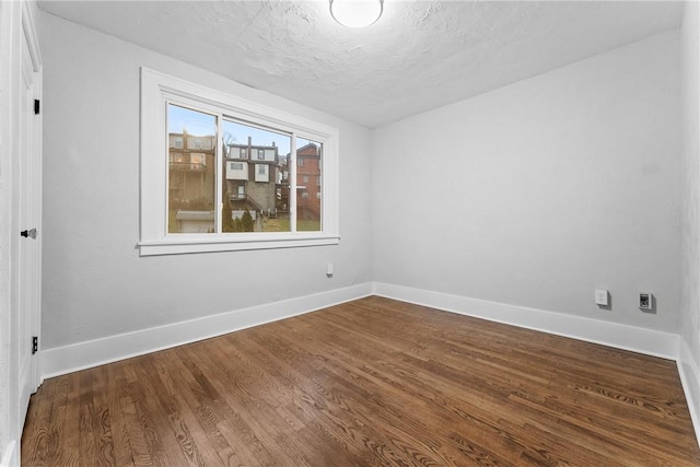 unfurnished room featuring hardwood / wood-style floors and a textured ceiling