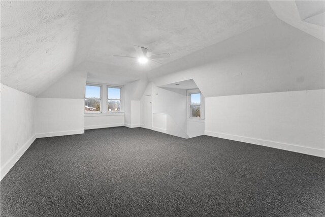 additional living space featuring ceiling fan, carpet floors, a textured ceiling, and lofted ceiling