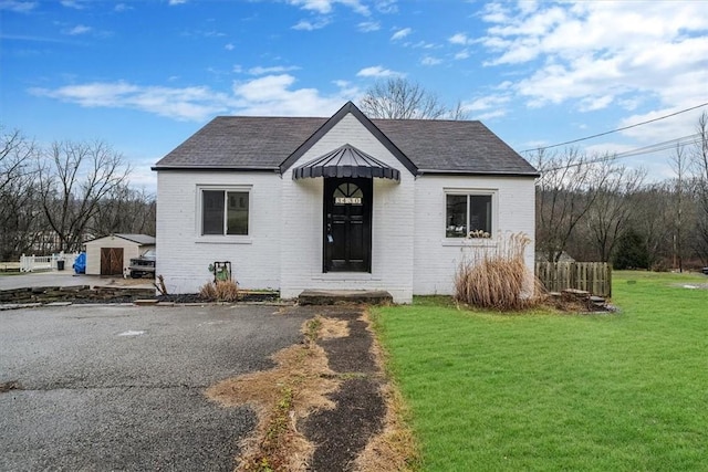 view of front of home featuring an outbuilding and a front yard