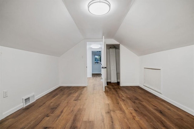 additional living space featuring dark hardwood / wood-style floors and lofted ceiling