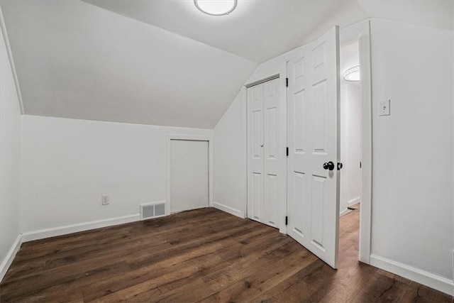 additional living space with dark hardwood / wood-style flooring and vaulted ceiling