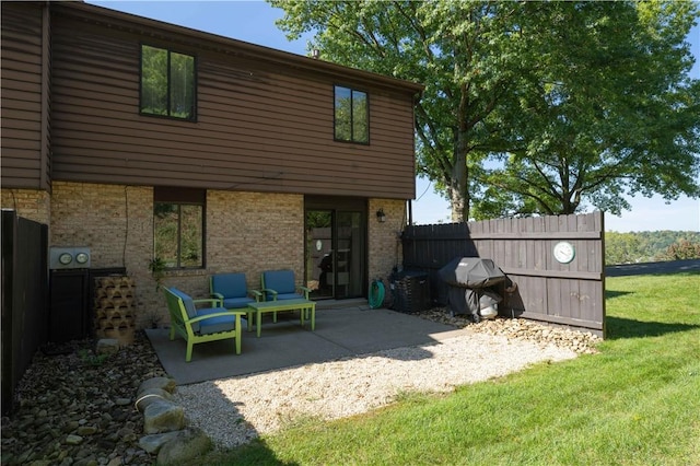 back of house with a patio and a lawn