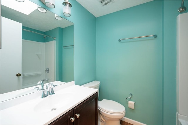 bathroom featuring a shower, vanity, and toilet