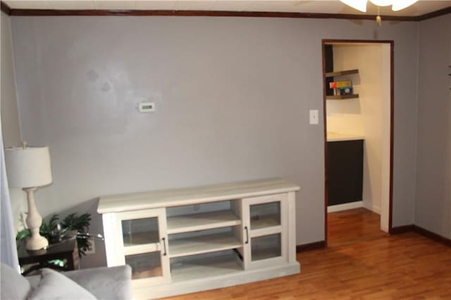 interior space with ceiling fan, wood-type flooring, and crown molding