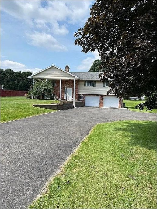 view of front of property with a front lawn and a garage