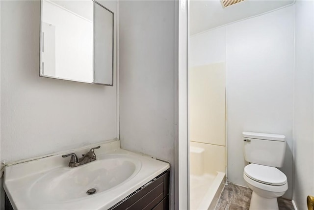 bathroom with vanity, toilet, and walk in shower