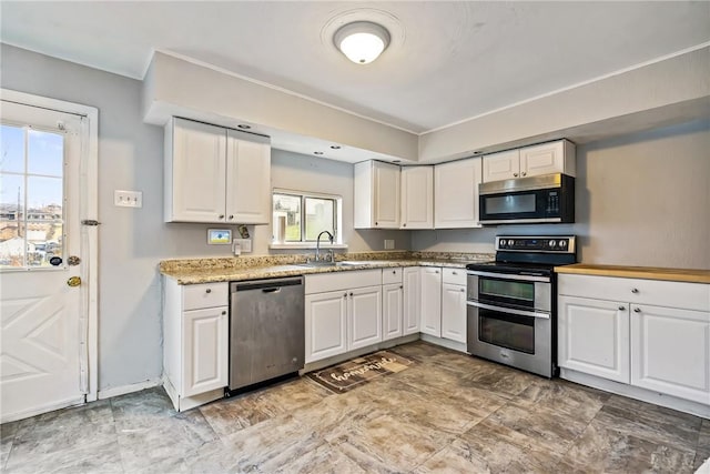 kitchen with sink, white cabinets, and appliances with stainless steel finishes