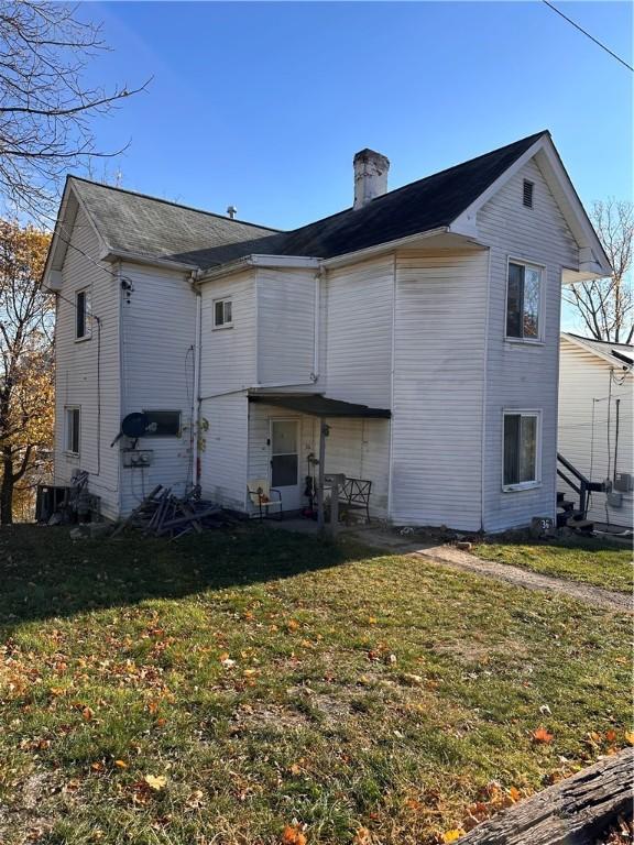 rear view of house featuring a yard