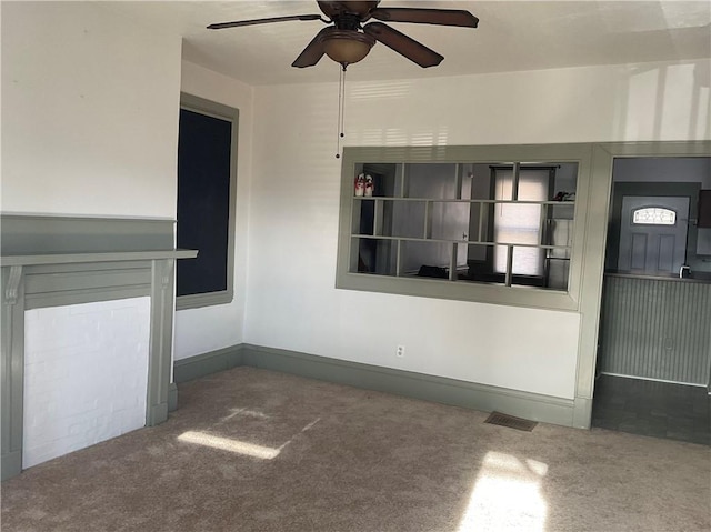 unfurnished living room featuring carpet flooring and ceiling fan