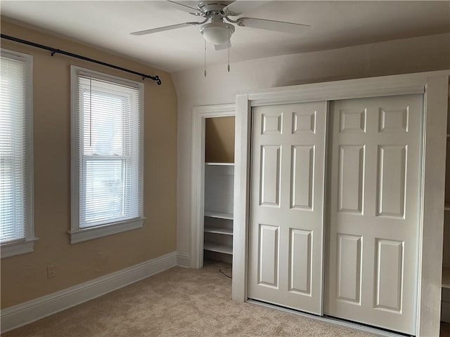 unfurnished bedroom with ceiling fan and light colored carpet