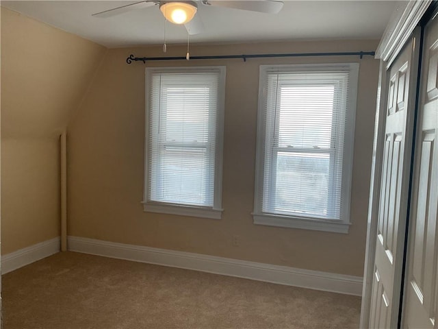 interior space with light carpet, lofted ceiling, ceiling fan, and a healthy amount of sunlight