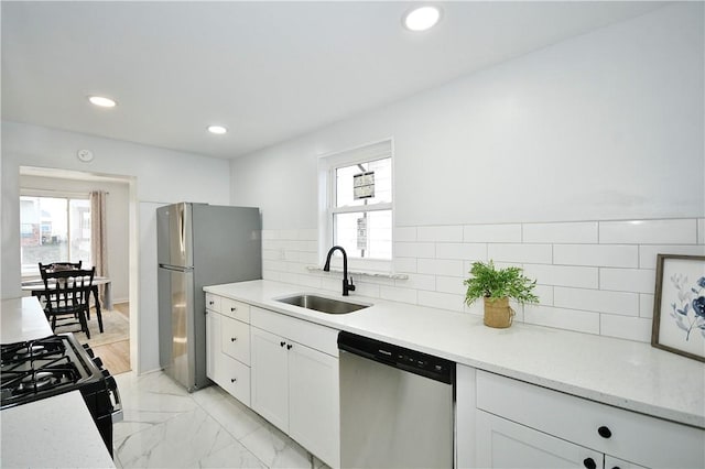 kitchen featuring white cabinetry, sink, appliances with stainless steel finishes, and tasteful backsplash