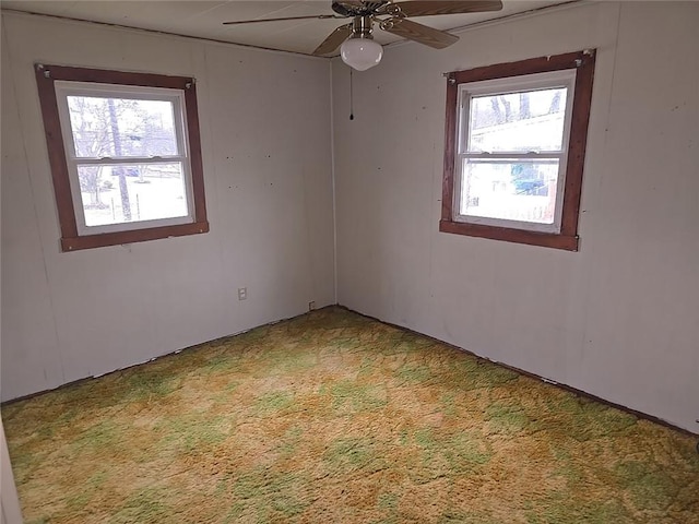 spare room featuring carpet flooring, a wealth of natural light, and ceiling fan