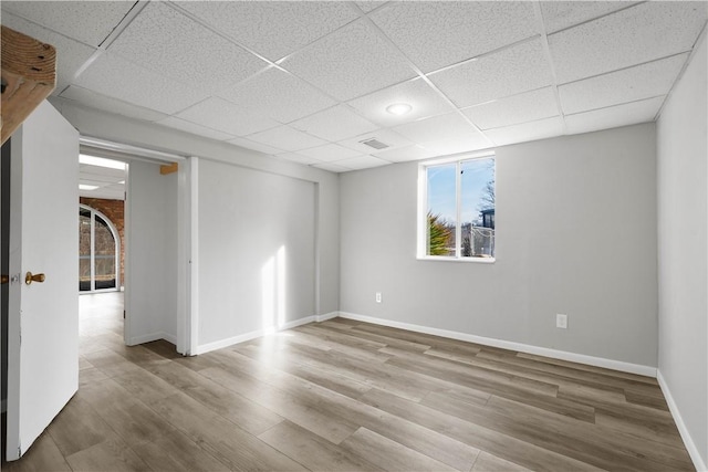 spare room featuring a drop ceiling and wood-type flooring