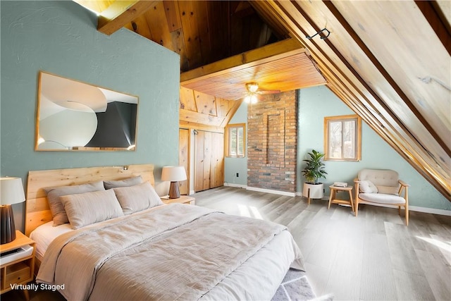 bedroom with lofted ceiling with beams and hardwood / wood-style flooring