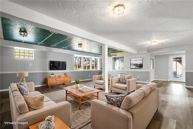 living room featuring wood-type flooring and a textured ceiling