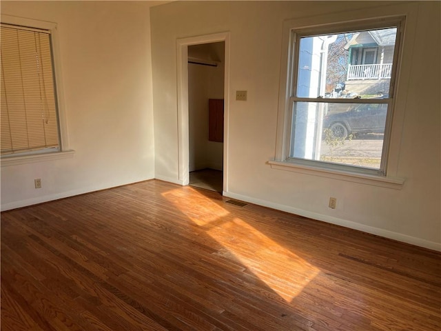 interior space with a wealth of natural light, hardwood / wood-style floors, and a wall mounted air conditioner