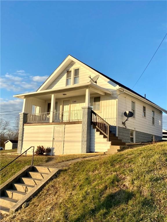 rear view of property with a yard and a balcony