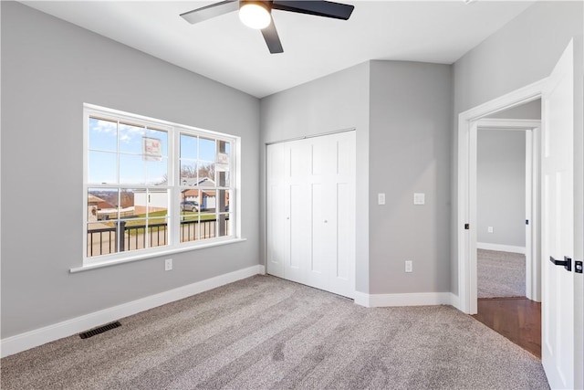 unfurnished bedroom featuring ceiling fan, a closet, and light colored carpet