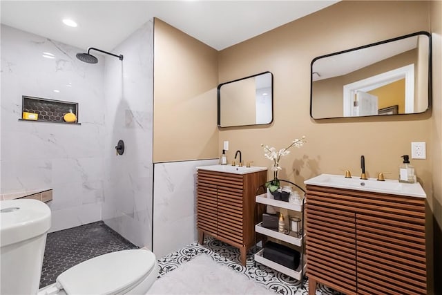 bathroom featuring a tile shower, tile patterned floors, vanity, and toilet